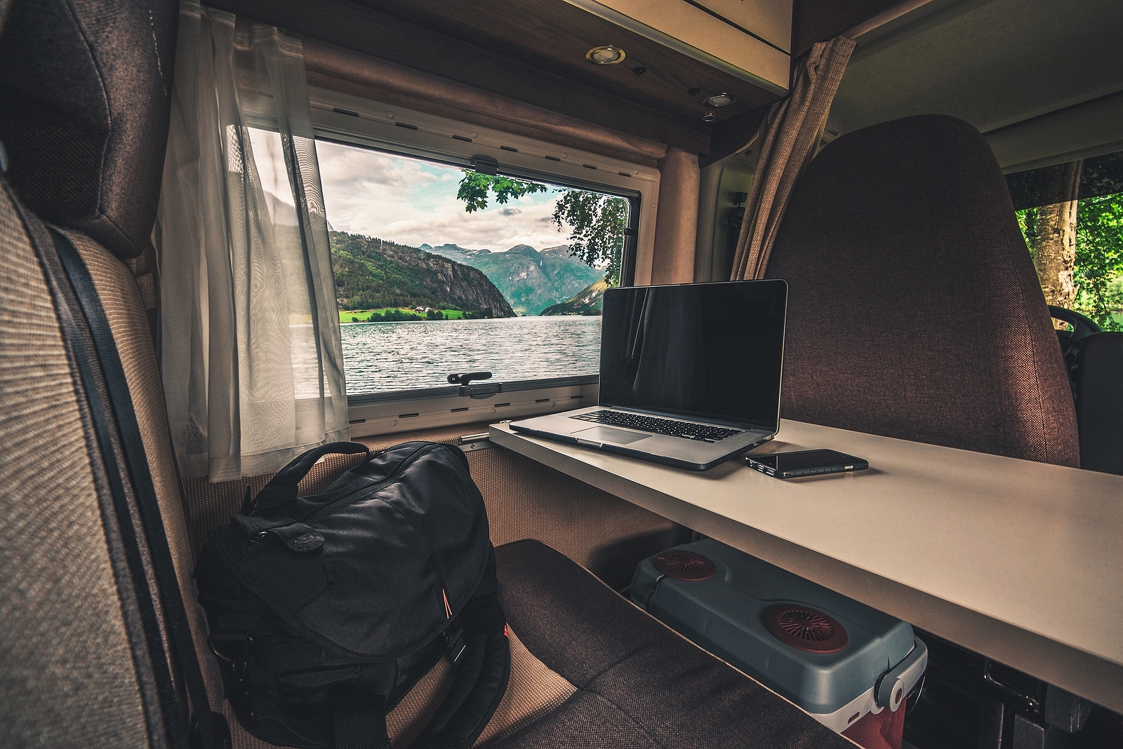 Work and Travel Concept. Laptop Computer on the Motorhome Table. Working While Traveling. Internet Connection While RVing.